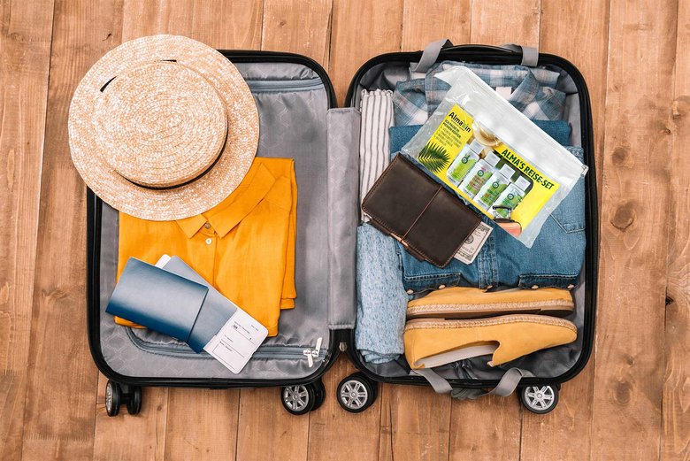 Unfolded packed suitcase with Alma's travel set